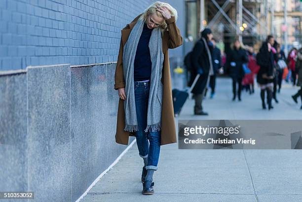 French model Aymeline Valade wearing dark blue denim jeans, a grey scarf and a brown coat seen outside Lacoste during New York Fashion Week: Women's...