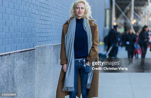 French model Aymeline Valade wearing dark blue denim jeans, a grey scarf and a brown coat seen outside Lacoste during New York Fashion Week: Women's...
