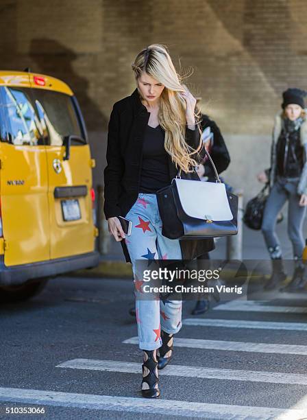 Guest is wearing blue denim jeans with printed stars seen outside Rebecca Minkoff during New York Fashion Week: Women's Fall/Winter 2016 on February...