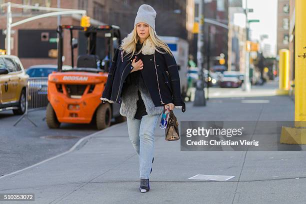 A guest wearing a blue jacket with fur and a fake fur jacket and blue denim jeans seen outside Rebecca Minkoff during New York Fashion Week: Women's...