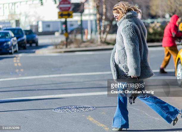 Olivia Palermo is wearing a fake fur coat and flared denim jeans seen outside Tibi during New York Fashion Week: Women's Fall/Winter 2016 on February...