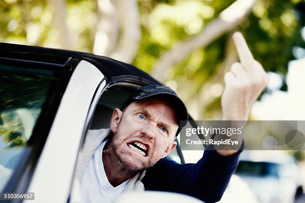 grimacing male driver makes obscene gesture at someone - doigt dhonneur stockfoto's en -beelden