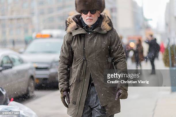 Nick Wooster is wearing a olive parka a fur hat and grey suit pants seen outside Lacoste during New York Fashion Week: Women's Fall/Winter 2016 on...