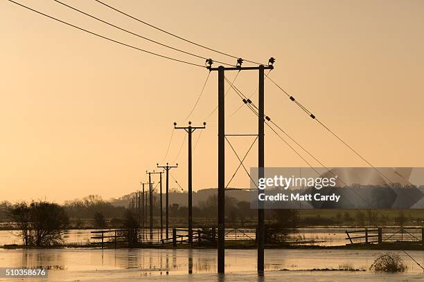 The winter suns rises over flood water still lingering in fields on the Somerset Levels below Burrow Mump on February 15, 2016 in Burrowbridge,...