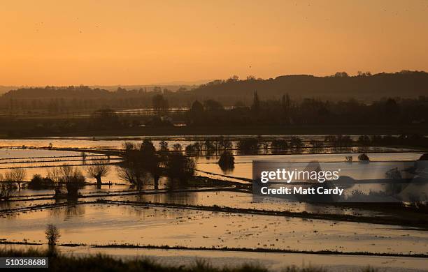 The winter suns rises over flood water still lingering in fields on the Somerset Levels below Burrow Mump on February 15, 2016 in Burrowbridge,...