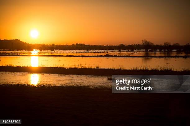 The winter suns rises over flood water still lingering in fields on the Somerset Levels below Burrow Mump on February 15, 2016 in Burrowbridge,...