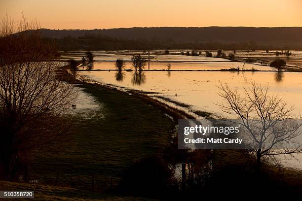 The winter suns rises over flood water still lingering in fields on the Somerset Levels below Burrow Mump on February 15, 2016 in Burrowbridge,...