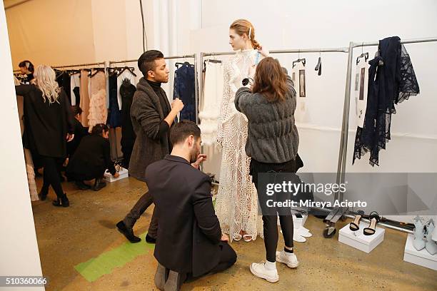 Fashion designer Jonathan Simkhai dresses a model backstage at the Jonathan Simkhai fashion show during Fall 2016 MADE Fashion Week at Milk Studios...