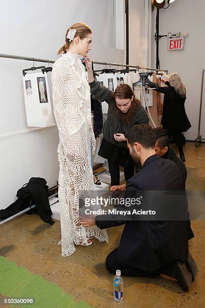 Fashion designer Jonathan Simkhai dresses a model backstage at the Jonathan Simkhai fashion show during Fall 2016 MADE Fashion Week at Milk Studios...
