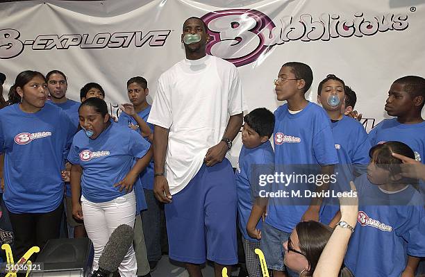 Rookie of the Year, LeBron James , blows a bubble as he stands near children while introducing the new Bubbilicious flavor "Carnival Cotton Candy"...