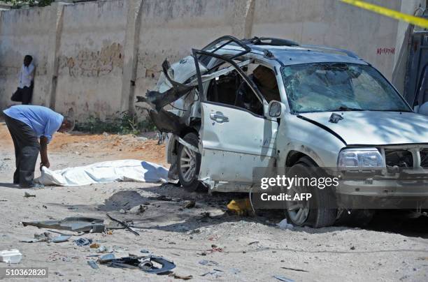 Resident adjusts a sheet covering the body of Somalia's former defence minister Muhidin Mohamed at the scene of an explosion on February 15 in the...