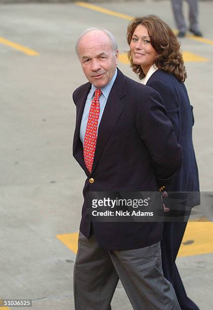 Former Former Enron CEO Kenneth Lay is escorted from a car and to a federal court by a law enforcement official after being indicted for wire fraud...