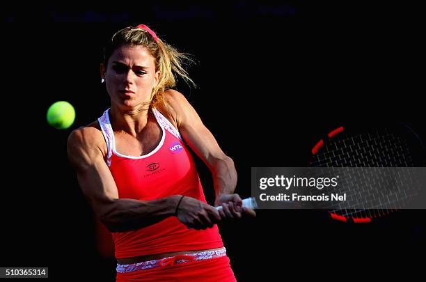 Camila Giorgi of Italy plays a backhand in her match against Andrea Petkovic of Germany during day one of the WTA Dubai Duty Free Tennis Championship...