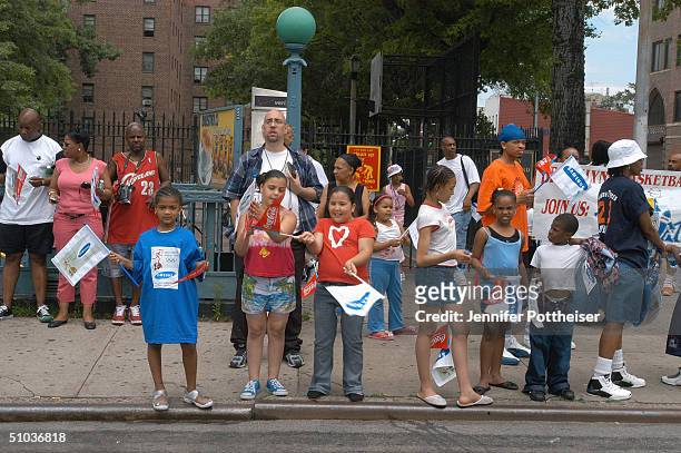 Young fans wave banners as they wait for Stephon Marbury of the New York Knicks to run by during the Olympic Torch Relay on June 4, 2004 in New York,...
