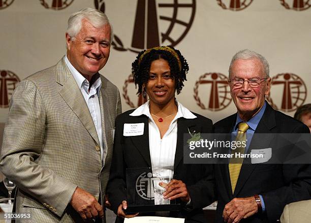 Jacqui Clay writer from the "Bernie Mac Show" accepts her awards from writer Allan Burns and director Gene Reynolds at The Humanitas Prize Awards at...