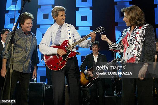 Democratic presidential candidate John Kerry plays the guitar as his wife Teresa Heinz and musician John Foggerty look on at a Kerry/Edwards 2004...