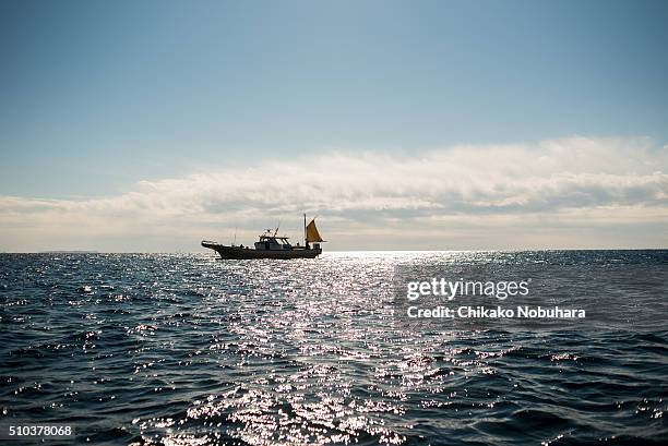 a fishing boat on the ocean - chigasaki beach stock pictures, royalty-free photos & images