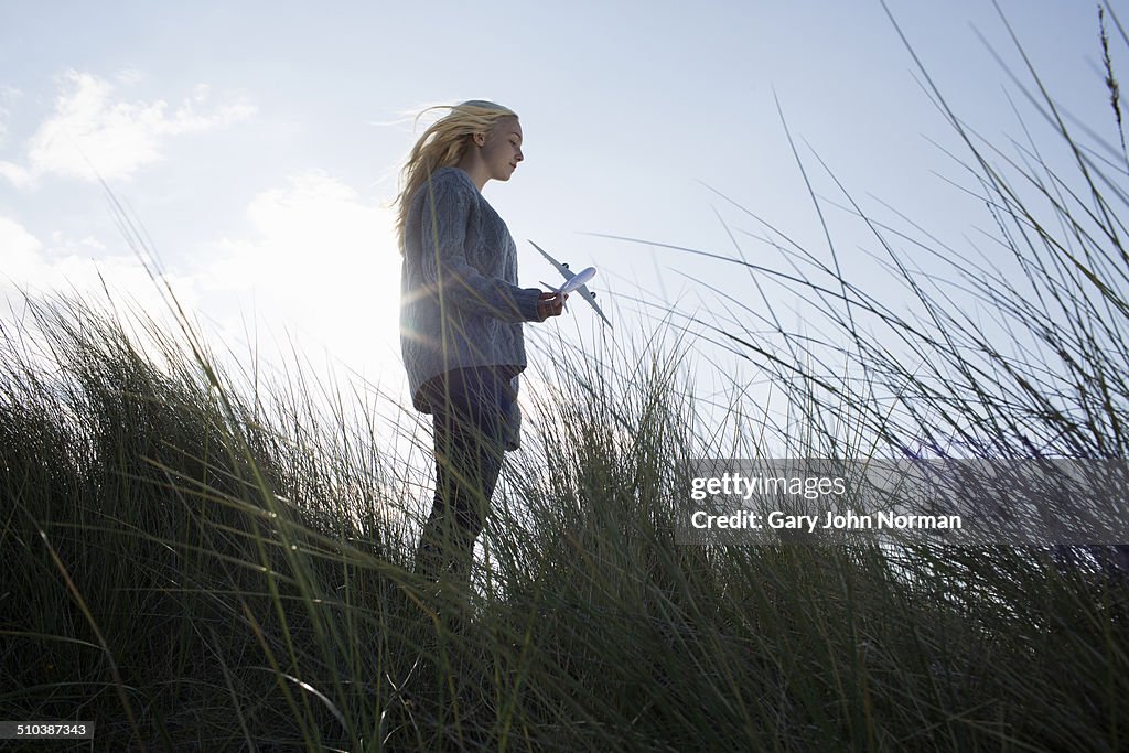 Teenage girl holding model aeroplane