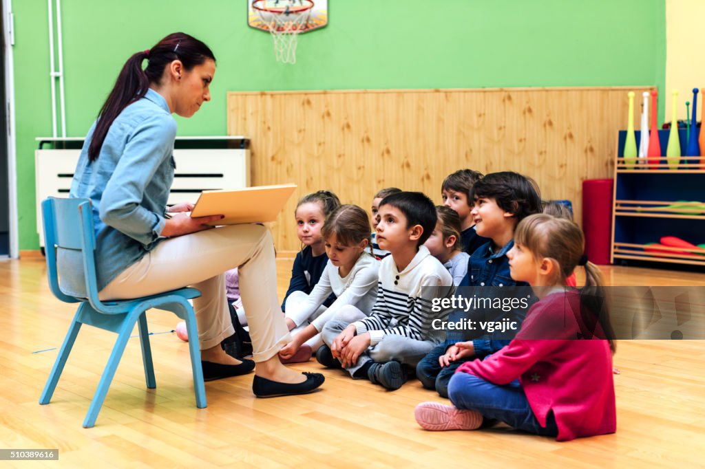 Preschool teacher and children in classroom