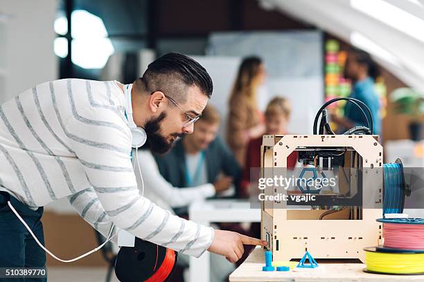 uomo al lavoro con stampante 3d in ufficio un'azienda start-up. - stampante 3d foto e immagini stock