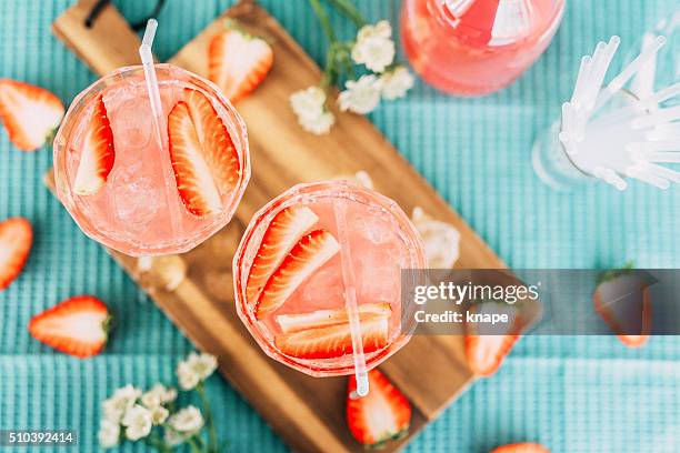 pink summer cocktail drink from above with strawberries - cocktail fruits stockfoto's en -beelden