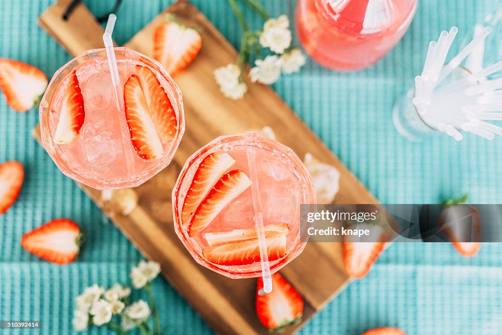 Pink summer cocktail drink from above with strawberries