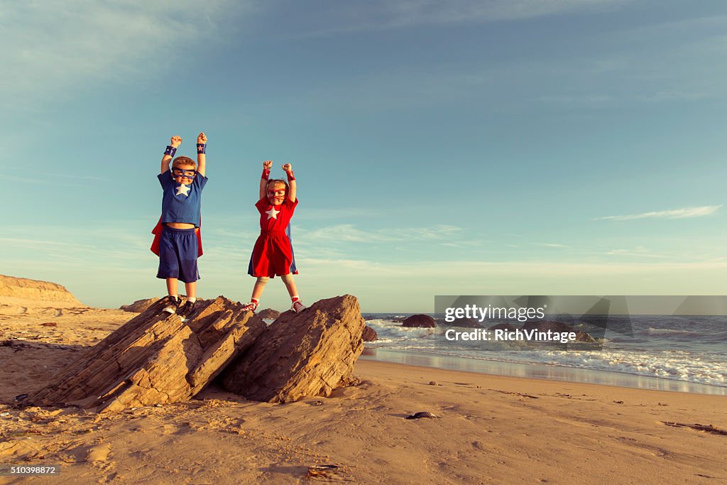 Ragazzo e ragazza Vestita come supereroi su spiagge della California