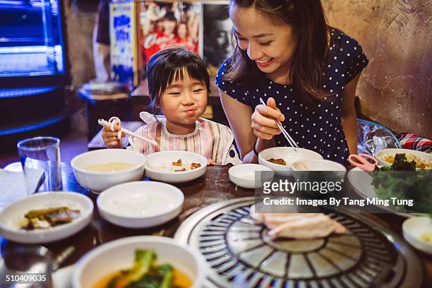 mom & child having meal in korean restaurant - chinese restaurant photos et images de collection