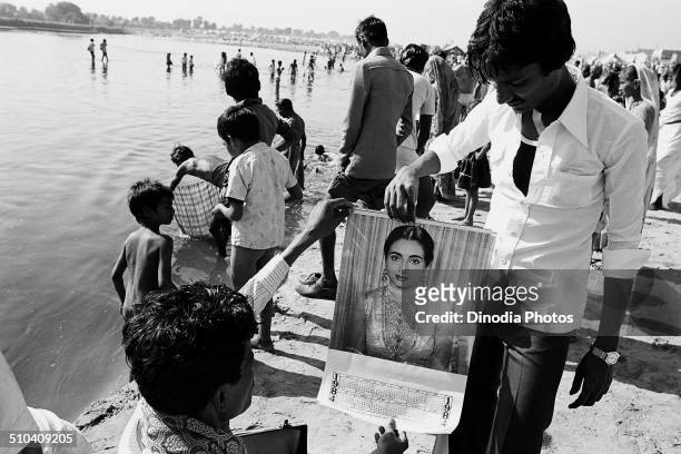 Man showing Bollywood calendar, Vautha fair, Gujarat, India, 1983