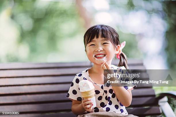 child having ice-cream in park joyfully - icecream stock pictures, royalty-free photos & images