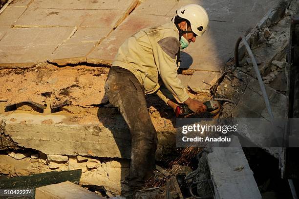 Rescue workers try to pull victims from the debris of a collapsed hospital, belongs to humanitarian aid organization "Doctors Without Borders" after...
