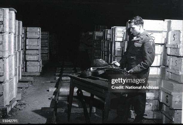 Us Soldier Inspects A Priceless Violin Taken From Jews By The Nazi's And Stashed In The Heilbronn Salt Mines May 3, 1945 In Germany. The Treasures...