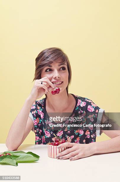 woman eating a cherry - kirschen tisch weiß stock-fotos und bilder