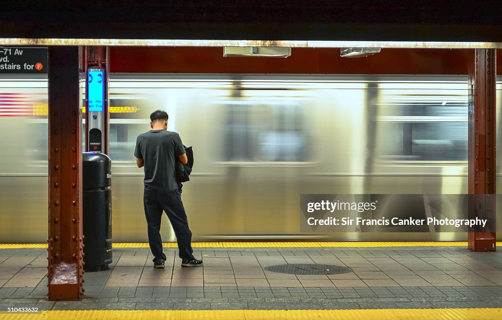 Person waiting as a metro train passes by at high speed