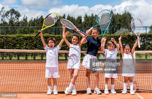 glückliche kinder spielen tennis - tennis stock-fotos und bilder