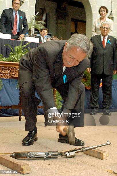 El presidente Oscar Berger rompe simbolicamente un arma al dar inicio al "Programa Nacional para el Desarme", el 09 de julio 2004, en Ciudad de...