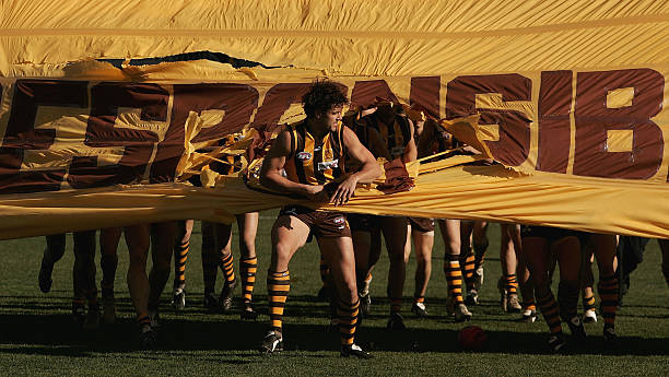 Nathan Thompson for the Hawks leads the team onto the ground for the round 15 AFL match between the Hawthorn Hawks and the West Coast Eagles at York...