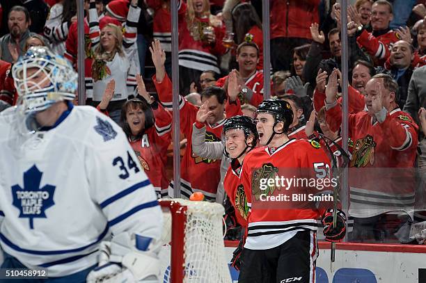 Dennis Rasmussen and Brandon Mashinter of the Chicago Blackhawks react behind goalie James Reimer of the Toronto Maple Leafs after Mashinter scored...