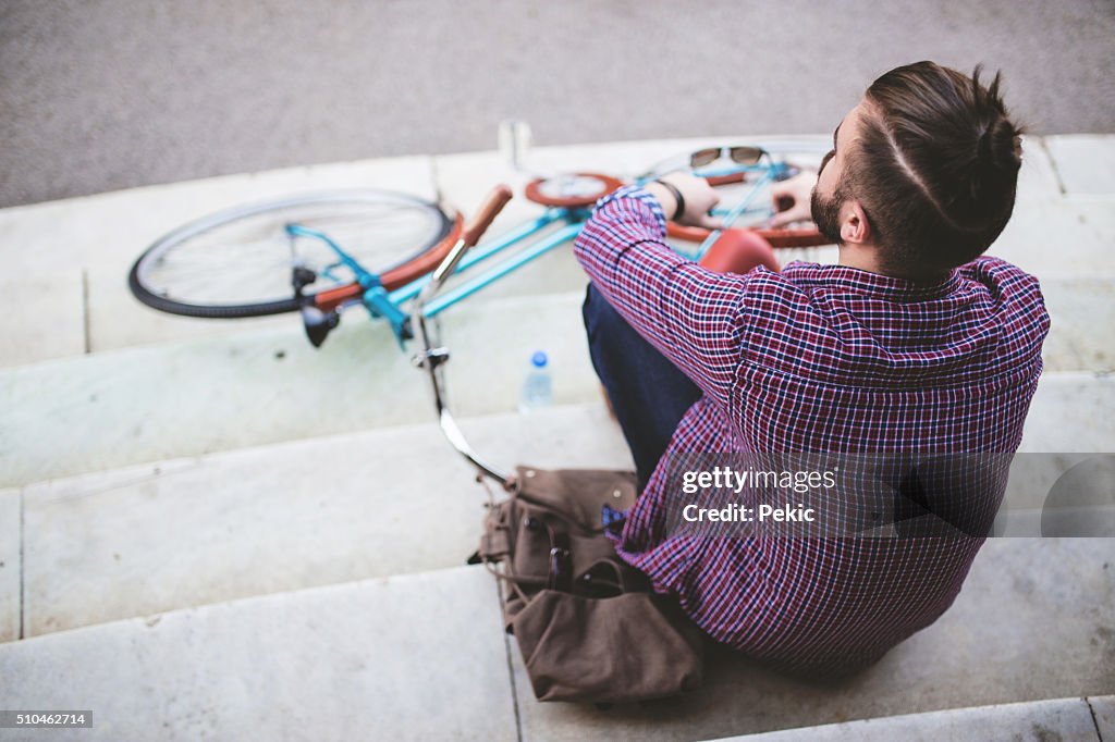 Homme avec un chignon relaxant dans la ville