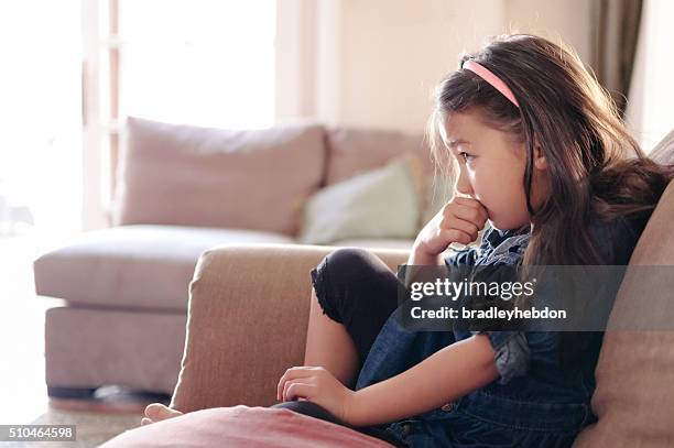 bella bambina di guardare la tv sul divano - anxiety foto e immagini stock
