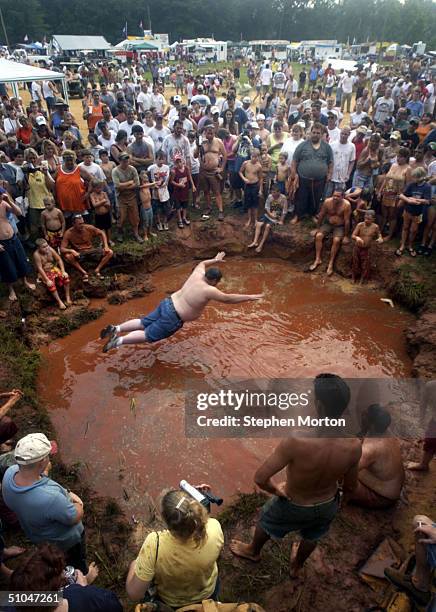 Contestant hovers just inches above the pit during the Mud Pit Belly Flop before finishing his dive during the 9th Annual Summer Redneck Games July...
