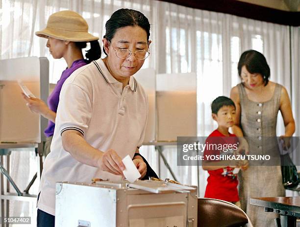 An elderly woman casts her vote for the Upper House election at a Tokyo polling station, 11 July 2004. Japanese voters expected to deliver a verdict...