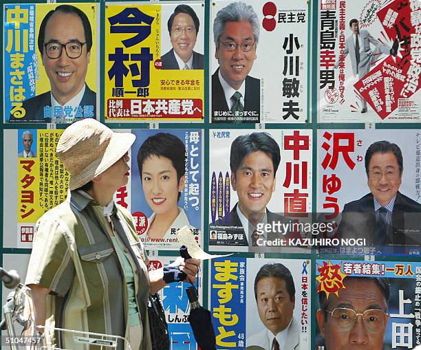 Woman walks past an election campaign posters in Tokyo, 11 July 2004. Japanese voters expected to deliver a verdict on Prime Minister Junichiro...