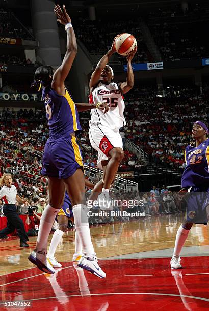 Dominique Canty of the Houston Comets shoots between Lisa Leslie and Nikki Teasley of the Los Angeles Sparks on July 10, 2004 at the Toyota Center in...