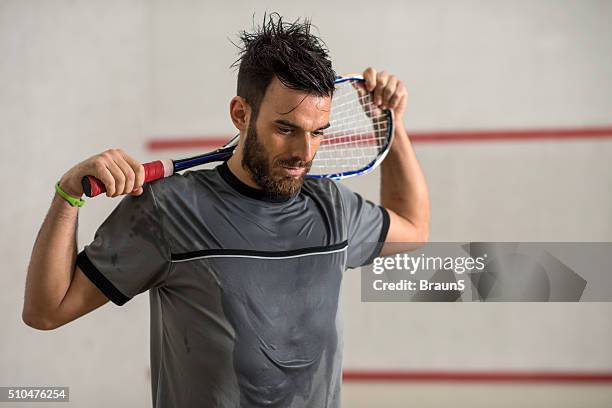 young exhausted squash player with a racket. - racketball stock pictures, royalty-free photos & images
