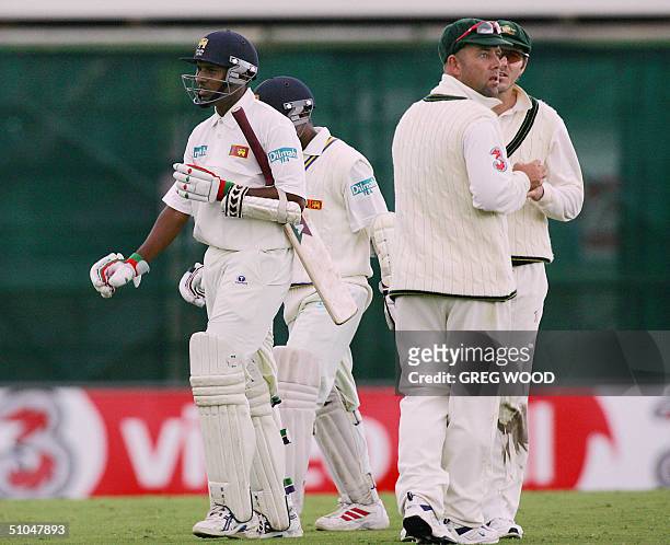 Sri Lankan batsmen Thilan Samaraweera and Romesh Kaluwitharana leave the field for a rain delay as Australian fieldsmen Darren Lehmann and Damien...