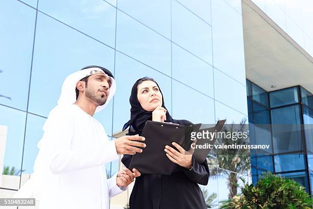 arab couple looking building for buying - emirati couple stock pictures, royalty-free photos & images