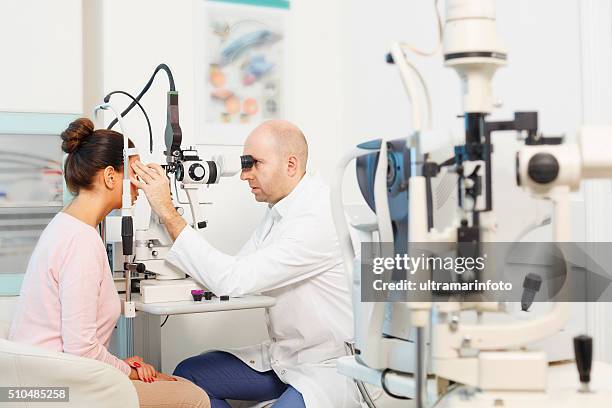 at the optician   ophthalmology   doctor ophthalmologist   optometrist medical eye examination - medical laser stockfoto's en -beelden