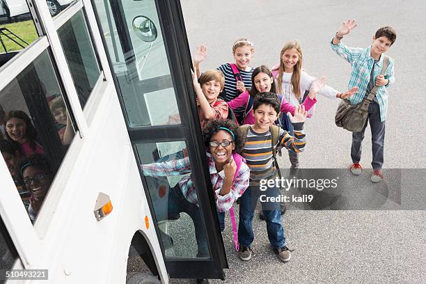 children getting on school bus - child waving at camera stock pictures, royalty-free photos & images