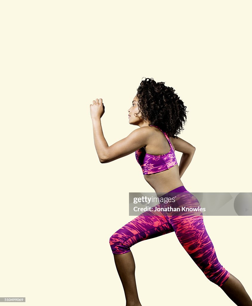 Dark skinned athletic female running, profile